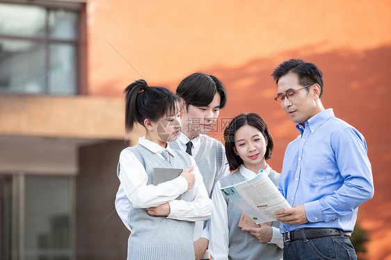 校园里学生和老师讨论课本知识图片