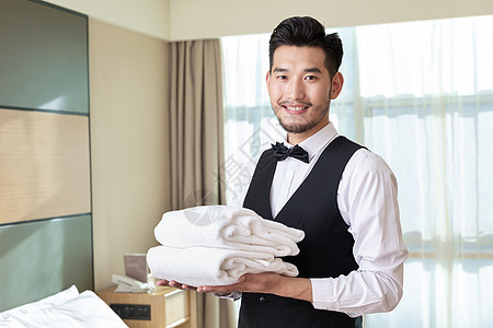 酒店客房服务员端浴巾背景图片
