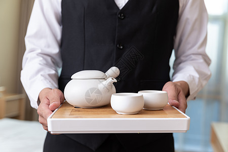 酒店客房服务员端茶具背景图片
