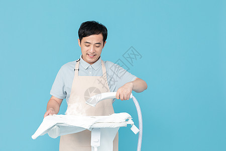 使用挂烫机熨烫衣服的家政服务男性高清图片