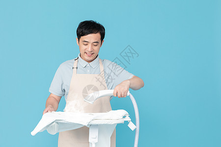 使用挂烫机熨烫衣服的家政服务男性图片