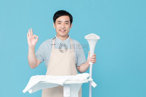 使用挂烫机的家政服务男性OK手势图片