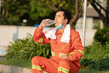 在马路旁喝水休息的环卫工人图片