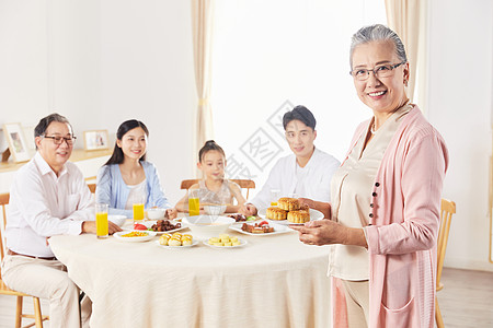 奶奶端着月饼给一家人吃图片