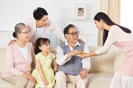 年轻妈妈的端着月饼给家人吃图片