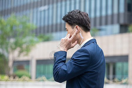 物业经理手扶耳机通话背影高清图片