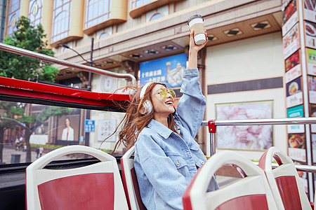 坐观光大巴旅游伸手欢呼的年轻女孩背景图片