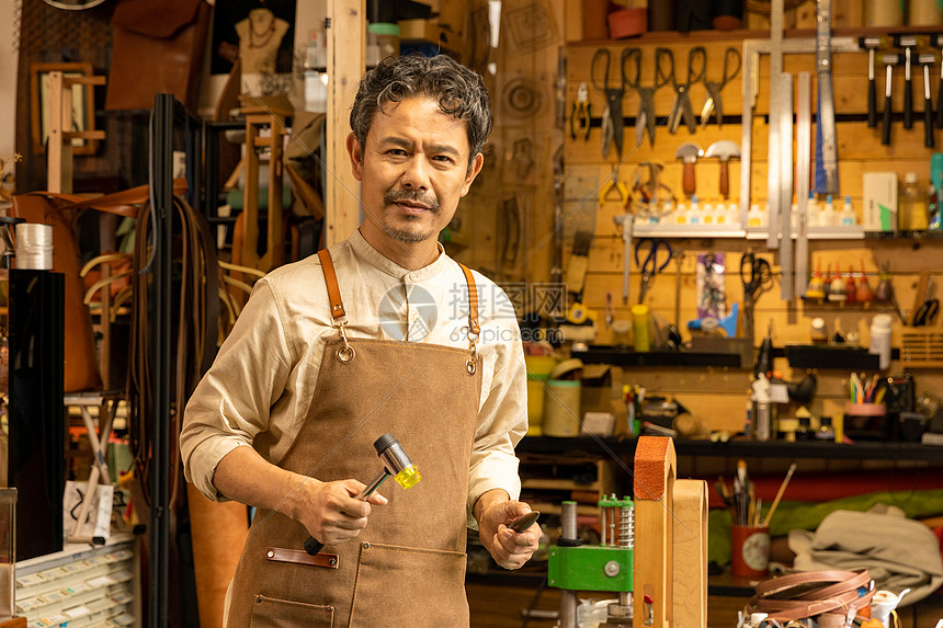 中年男性皮匠工匠手拿工具图片