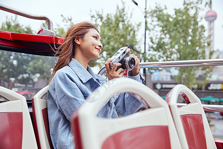 国庆欢乐购坐观光大巴旅游拍照的年轻女孩背景