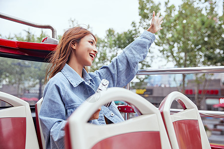 国庆欢乐购坐观光大巴旅游拍照的年轻女孩背景