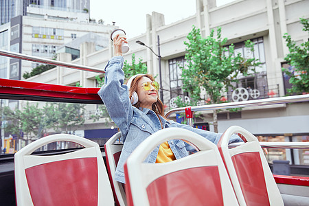 客服美女坐观光大巴旅游伸手欢呼的年轻女孩背景