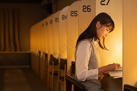 深夜在自习室里学习的女学生背景图片