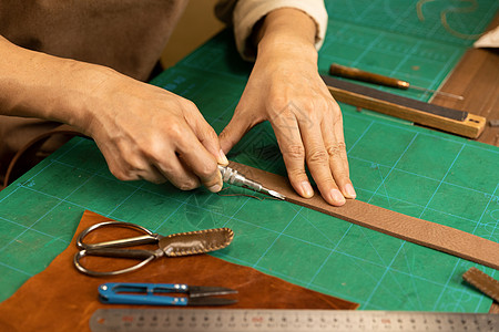 中年男性皮匠手工缝制皮带细节图片