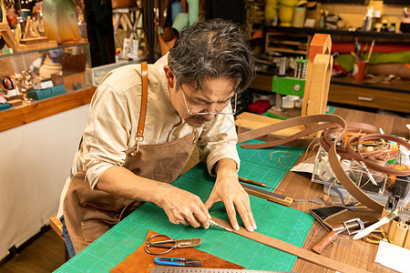 中年男性工匠手工定做皮带背景图片