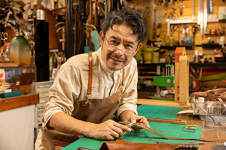 中年男性工匠手工定做皮带背景图片