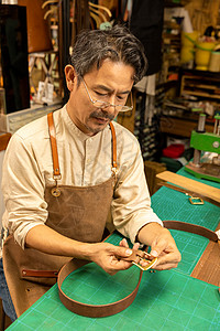 中年男性工匠手工定做皮带背景图片