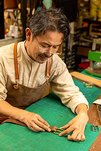 中年男性工匠手工定做皮带背景图片