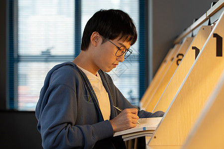 学生写男学生清晨自习室复习功课背景