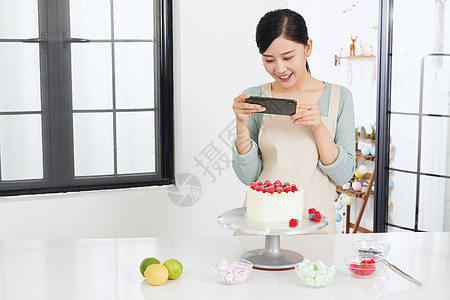 美女居家制作水果蛋糕用手机拍照图片