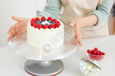 女性手工制作水果蛋糕特写图片