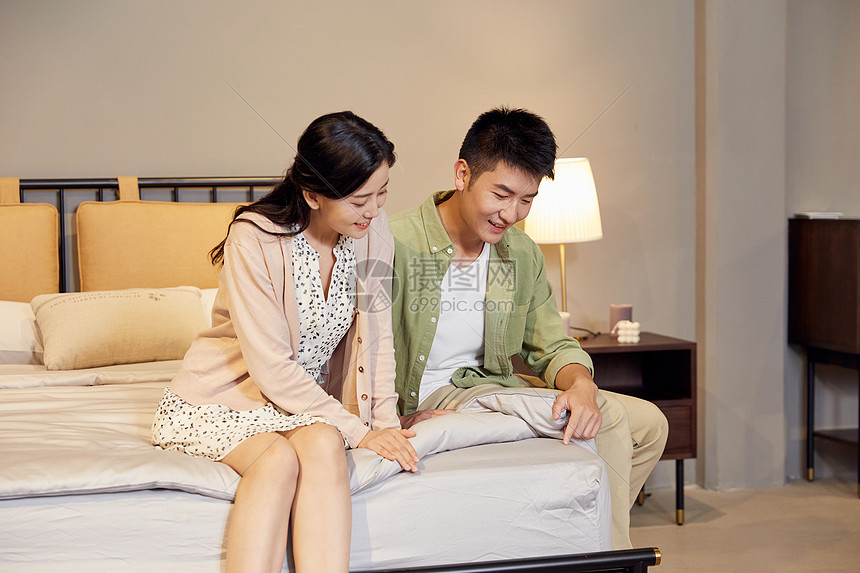 年轻夫妻家具店讨论床垫舒适度图片