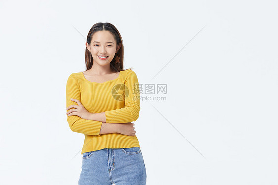 穿着淡黄毛衣的年轻美女双手抱胸图片