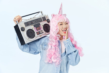 录音机放在肩膀上的时尚粉色长发美女图片