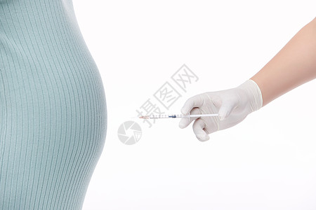 女性健康针管对着孕妇的肚子背景