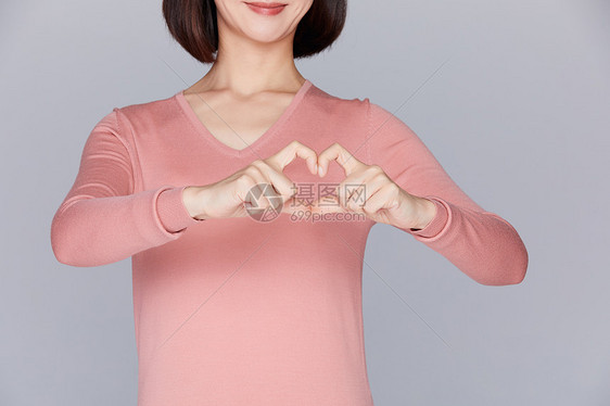 关爱女性胸部健康女性在胸口比划爱心图片