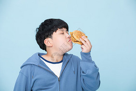 爱吃汉堡的男孩肥胖的小孩闻食物儿童高清图片素材
