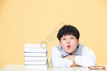 儿童写作业在书旁边惊讶的小男孩背景