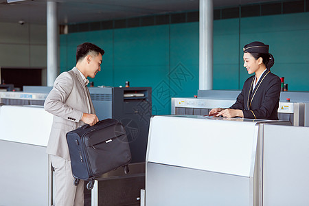 空中乘务员乘客和空姐在托运台前交流背景