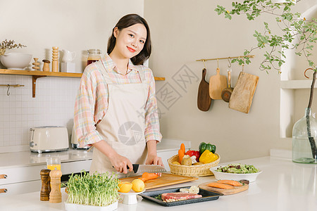 厨房切胡萝卜的甜美女孩图片