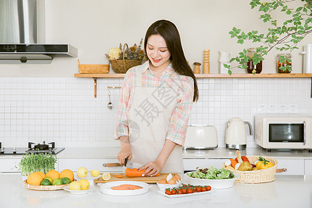 做饭美女厨房切胡萝卜的甜美女孩背景