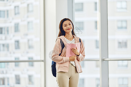 考研学子女生手捧书本微笑形象背景图片