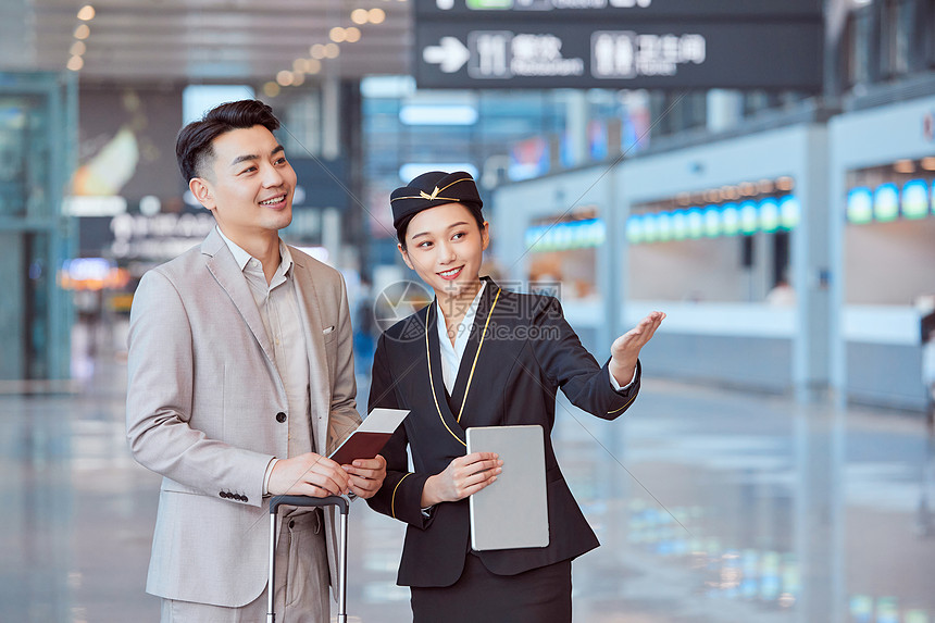 机场大厅男性乘客向空姐问路