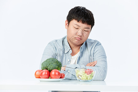 多吃蔬菜水果讨厌吃蔬菜水果的肥胖小男孩背景