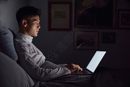 熬夜加班的男孩夜晚居家男士使用电脑加班办公打字背景
