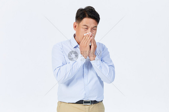 打喷嚏用纸巾遮挡的中年男性图片