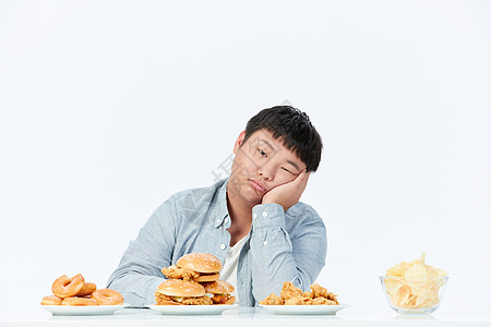 面对油炸食品食欲不振的小胖子图片素材