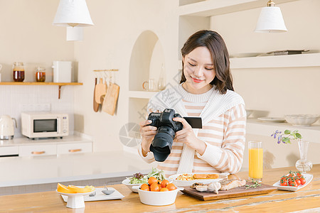 居家女孩使用相机拍摄美食图片