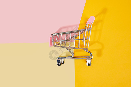 拼接色彩背景上的粉色购物车背景图片