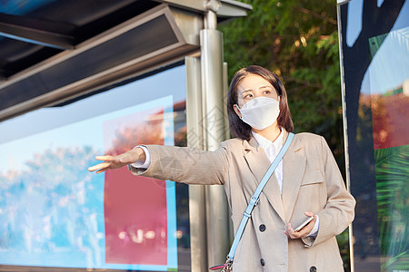 戴口罩公交站台打车的青年女生图片