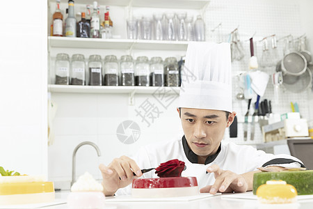 男性烘焙师制作水果玫瑰慕斯蛋糕图片