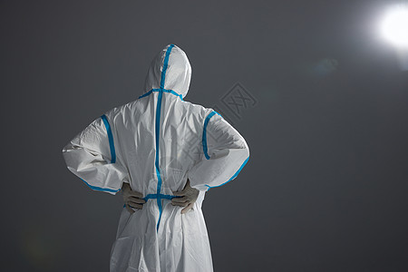 穿着防护服的医护人员腰背酸痛背影高清图片