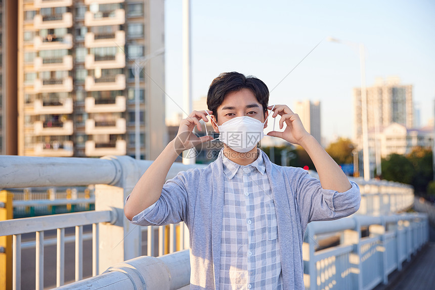 户外佩戴口罩的青年男性图片