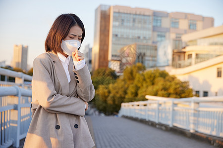 户外佩戴口罩咳嗽的青年女性图片