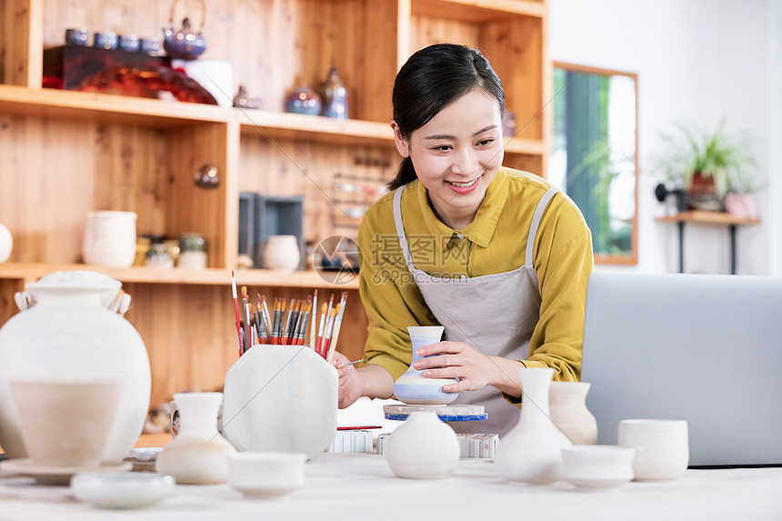 美女陶艺匠人绘制陶艺品图片