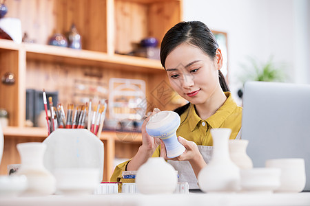 美女匠人展示陶艺品图片