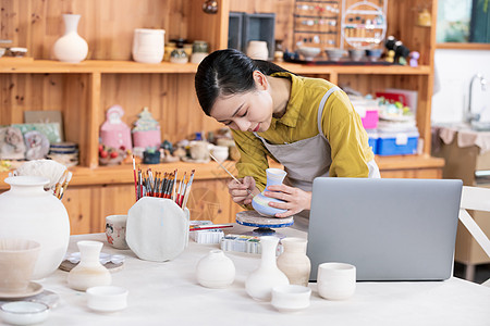 美女工匠绘制陶艺瓶图片